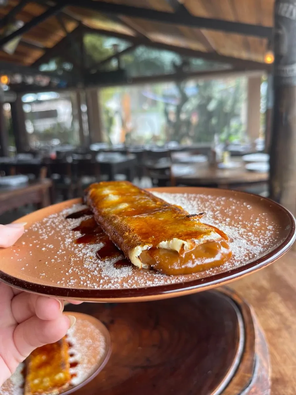 Panqueca Uruguaia com doce de leite e açúcar, salão ao fundo